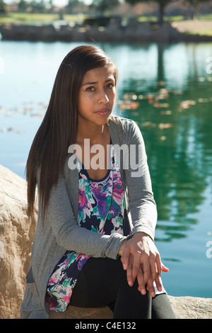 Hispanic girl sitting in nature profonde réflexion rêve réfléchis réfléchis assis à rêver assis à méditer sérieusement monsieur © Myrleen Pearson Banque D'Images