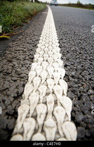 Ligne blanche / chaussée de marqueur pointe sur une route de campagne au Royaume-Uni. Banque D'Images