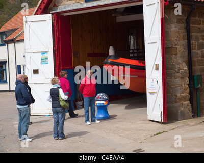 Les touristes à la recherche à l'embarcation de sauvetage de la RNLI embarcation rapide de sauvetage semi rigide à Staithes, Yorkshire du Nord. Banque D'Images