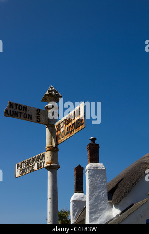 Georgeham, Woolacombe, Taunton, Croyde Bay. Ancien panneau de signalisation britannique, panneau de rue pour différentes destinations. Cottage de chaume à North Devon, Royaume-Uni Banque D'Images