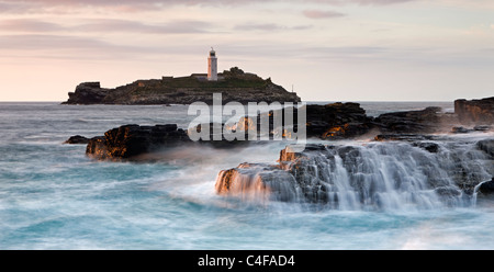 Les vagues déferlent sur les rochers au Godrevy Point, à l'extérieur, vers le phare sur l'île de Godrevy, Cornwall, Angleterre. Banque D'Images