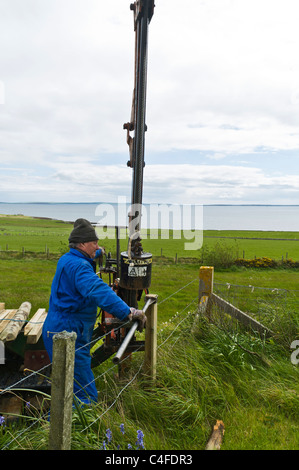 dh FARMING ORKNEY borne à chenilles à faible impact, poste de conduite hydraulique poste de clôture de conduite barbwire de clôture de poste de travail équipement de machine de l'entrepreneur Banque D'Images