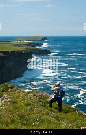 dh Scottish Seacliffs UK BIRSAY ORKNEY ornithologue avec des jumelles oiseau observateur falaise mer homme observateurs vues sur la côte d'écosse Banque D'Images