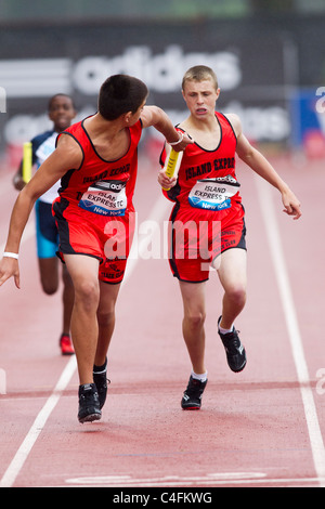 Baton passer par la voie express de l'île Club à le garçon du relais 4x400m au 2011 NYC piste Grand Prix et de la concurrence sur le terrain. Banque D'Images