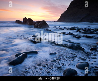 Marée haute sur la plage au coucher du soleil, Duckpool North Cornwall, Angleterre. Printemps (mars) 2011. Banque D'Images