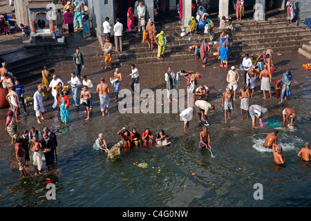 Pèlerins hindous se baigner dans l'eau sacrée de la rivière Godavari. Ram Kund. Nashik. Maharastra. L'Inde Banque D'Images