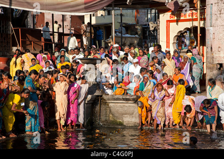 Les femmes indiennes se baigner dans l'eau sainte de la rivière Godavari. Nasik. L'Inde Banque D'Images