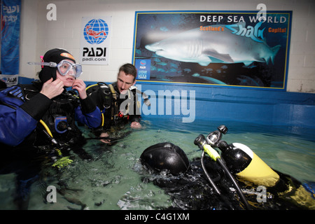 Divers kit-up avant d'entrer dans l'aquarium de Deep Sea World à plonger avec les requins tigre de sable qui sont les principales attractions Banque D'Images