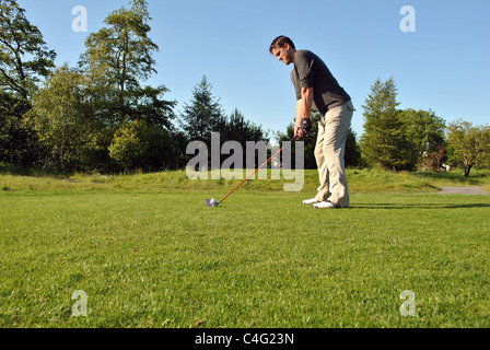 Male golfer sur un raccord en t fort prêt à prendre une photo Banque D'Images