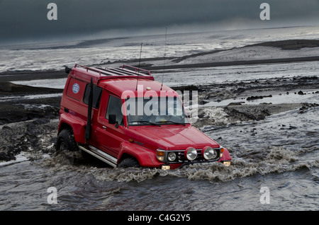 Big Red traversant la rivière glaciaire Tungnaa rempli de cendres de l'éruption volcanique en Islande, Grimsvotn Banque D'Images