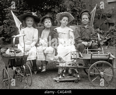 Diapositive originale en verre négative de classe supérieure victorienne ou Enfants édouardiens assis dans le jardin avec de nombreux jouets Banque D'Images