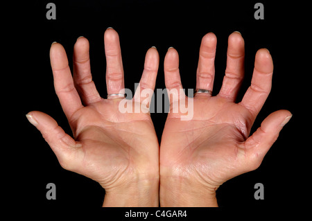 Femme montrant des mains ouvertes. Sur fond noir propre. Banque D'Images