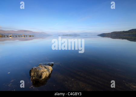Réflexions sur le Loch Lomond, de Duck Bay, sur la rive sud du Loch, en Écosse. Ben Lomond est dans la distance. Banque D'Images