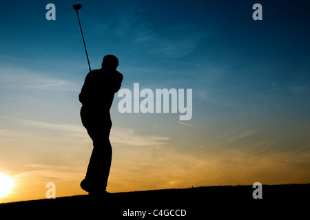 Senior golf - représenté comme une silhouette contre un ciel du soir Banque D'Images