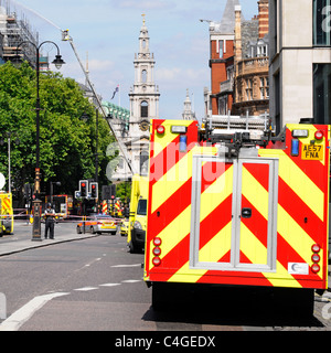 Échelle télescopique et plate-forme d'accès pompier au travail visant l'eau à l'incendie du toit dans les véhicules Strand Fire police et ambulance Londres Angleterre Royaume-Uni Banque D'Images
