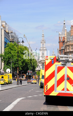 Les services d'urgence police pompiers & ambulances pompiers scène de rue vise l'eau à toit fire & smoke Strand London UK Banque D'Images