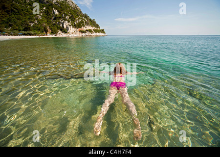 Jeune femme avec pink Bikini nager dans l'eau claire de la plage de Limnonari île de Skopelos, Sporades du Nord, Grèce Banque D'Images