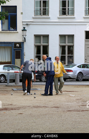 Les hommes belges profitez d'un jeu de boules sur une place de Bruges Banque D'Images