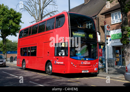 Un nouveau bus à seulement quelques semaines d'attente à un arrêt d'autobus avant de partir sur son vélo à Romford Banque D'Images