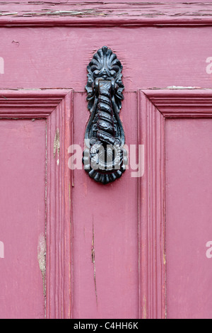Heurtoir en fer forgé sur la porte rose Banque D'Images