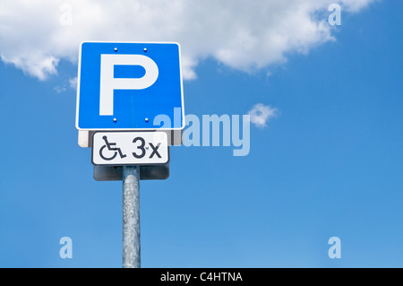 Signe de stationnement pour personnes handicapées et ciel bleu avec des nuages Banque D'Images