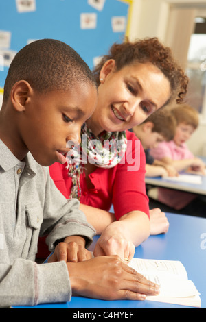 L'étude d'écolier en classe avec l'enseignant Banque D'Images