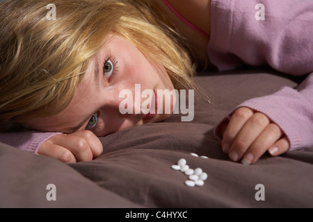 Déprimé Teenage Girl Sitting in chambre avec Pills Banque D'Images