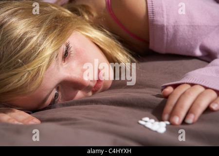 Déprimé Teenage Girl Sitting in chambre avec Pills Banque D'Images