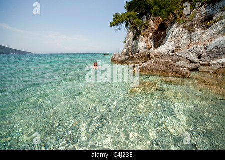 Jeune femme nageant dans l'eau claire de Gialos plage Kastani, Mamma Mia film emplacement sur l' île de Skopelos, Grèce Banque D'Images