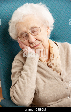 Senior Woman Resting in Chair At Home Banque D'Images