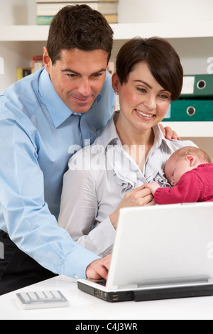 Les parents de nouveau-né à domicile Using Laptop Banque D'Images