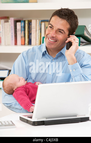 Père avec nouveau-né travailler à domicile à l'aide de coffre Banque D'Images