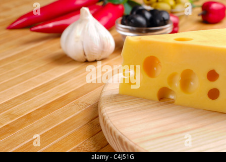 Fromage Emmental ou maasdam avec des légumes sur la table Banque D'Images