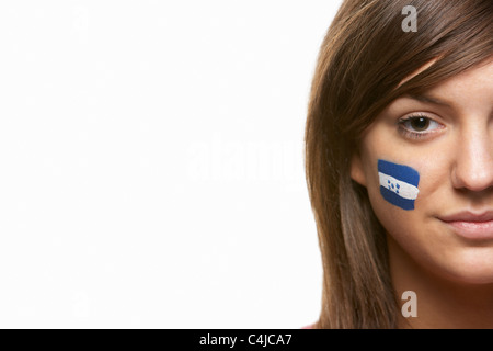 Jeune femme fan de sport avec drapeau Honduras sur le visage peint Banque D'Images