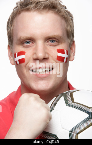 Jeune homme amateur de football avec drapeau danois peint sur le visage Banque D'Images