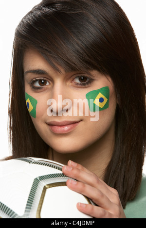 Les jeunes fans de football féminin avec drapeau brésilien peint sur le visage Banque D'Images