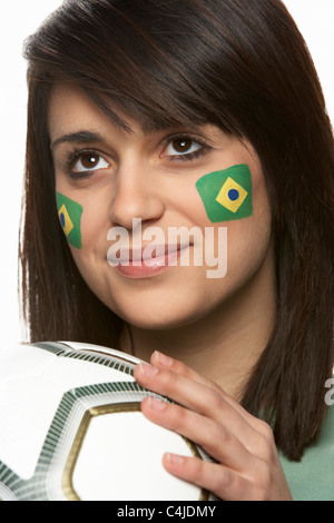 Les jeunes fans de football féminin avec drapeau brésilien peint sur le visage Banque D'Images