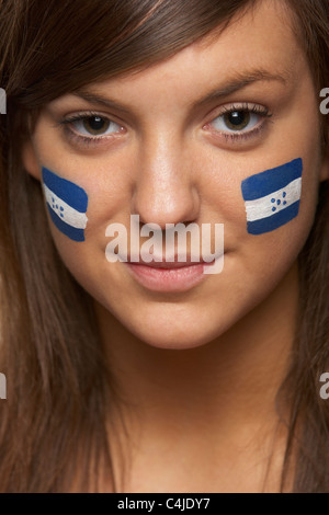 Jeune femme fan de sport avec drapeau hondurien sur le visage peint Banque D'Images