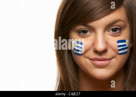 Jeune femme fan de sport avec drapeau uruguayen a peint sur le visage Banque D'Images