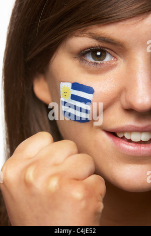 Jeune femme fan de sport avec drapeau uruguayen a peint sur le visage Banque D'Images