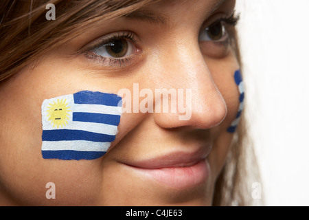 Jeune femme fan de sport avec drapeau uruguayen a peint sur le visage Banque D'Images