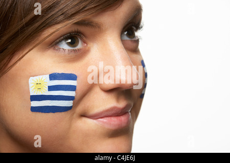 Jeune femme fan de sport avec drapeau uruguayen a peint sur le visage Banque D'Images