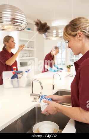 Team of Commercial Cleaners Working in Domestic Kitchen Banque D'Images