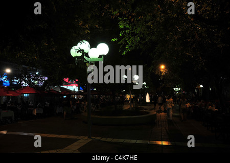 Nuit noire vue en temps réel de la lumière blanche des lampes au néon, rue d'ornement et les personnes qui s'y manger, Paseo Sarmiento, Mendoza, Argentine Banque D'Images