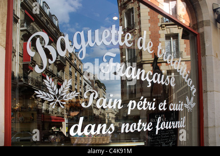 Une rue de Paris reflète dans une boulangerie vitrine Banque D'Images