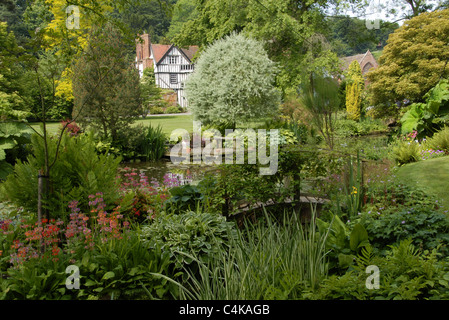 Un paysage plein de scène un jardin typiquement anglais Tudor house,avec en arrière-plan, de fleurs et d'eau Banque D'Images