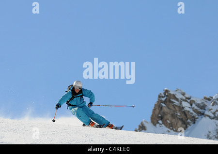 Un skieur se sculpte un tour sur piste dans la station de ski française de Courchevel. Banque D'Images