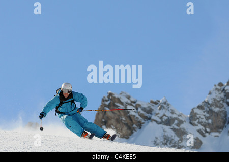 Un skieur se sculpte un tour sur piste dans la station de ski française de Courchevel. Banque D'Images