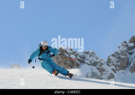 Un skieur se sculpte un tour sur piste dans la station de ski française de Courchevel. Banque D'Images