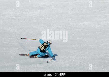 Un skieur se sculpte un tour sur piste dans la station de ski française de Courchevel. Banque D'Images